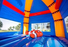 un chateau gonflable maxifun super bleu avec un poisson clown en 3D sur la partie du saut