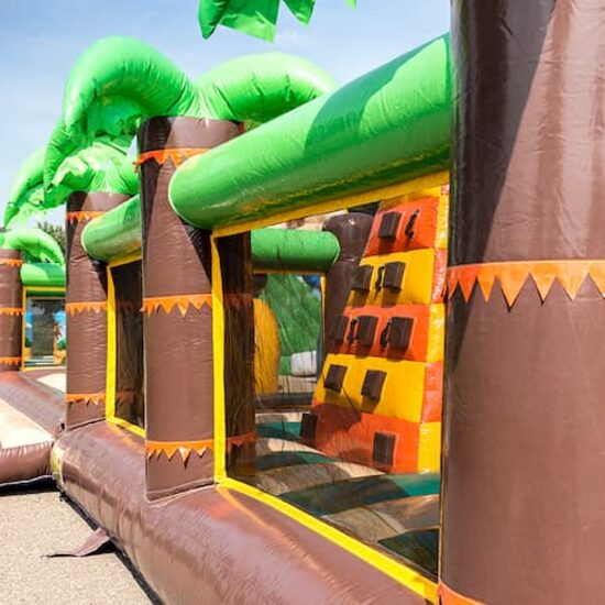 Parc gonflable de la jungle Bounce World avec plusieurs toboggans et toutes sortes d'obstacles amusants avec des imprimés de la jungle pour les enfants. Achetez des structure gonflables en ligne chez JB Gonflables France