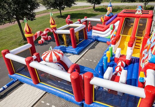Aire de jeux gonflable du cirque Bounce World avec plusieurs toboggans et toutes sortes d'obstacles amusants avec des imprimés de cirque pour les enfants. Achetez des structure gonflable en ligne chez JB Gonflables France