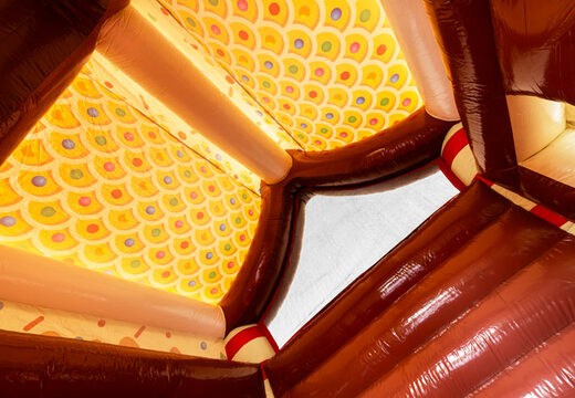 Toit du château gonflable couvert décoré comme une maison en pain d'épices dans le thème du pain d'épices